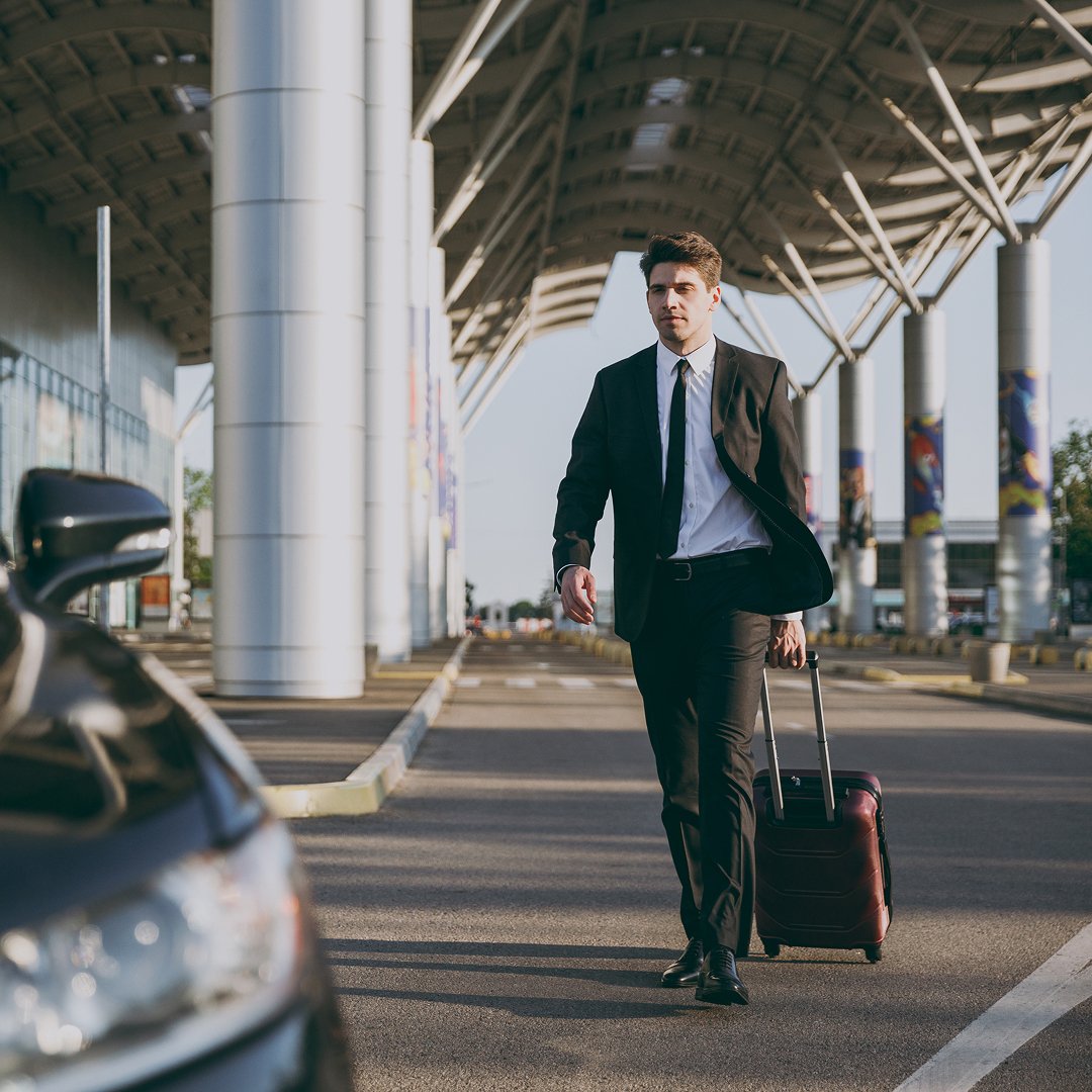 Traveler with luggage outside a terminal